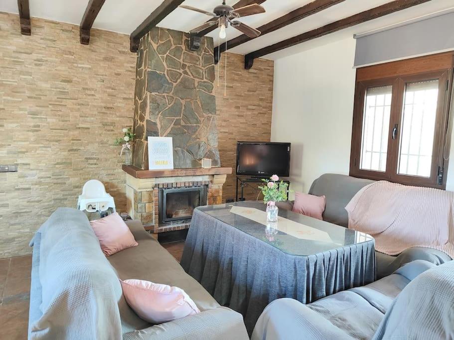 Sala de estar con 2 sofás y mesa en Relax, vistas, barbacoa y piscina, junto a Ronda en Arriate