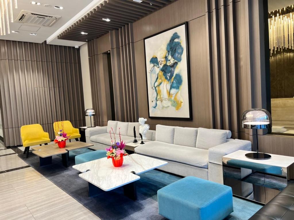 sala de estar con sofá, mesas y sillas amarillas en Uptown Parksuites II, en Manila