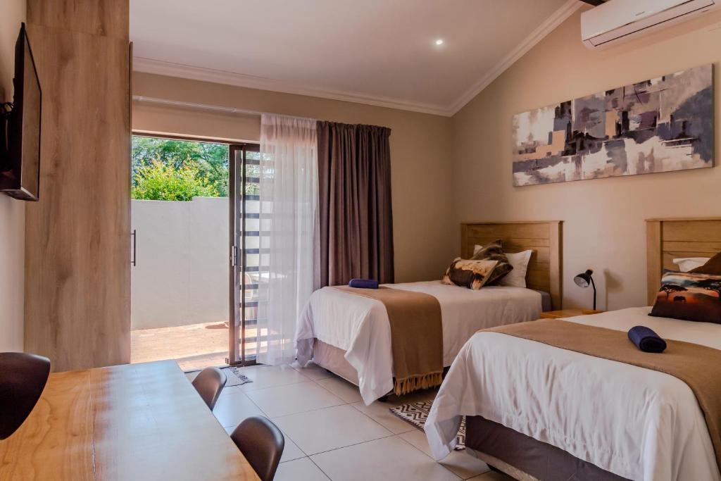 a hotel room with two beds and a balcony at Guest On Wynne in Centurion