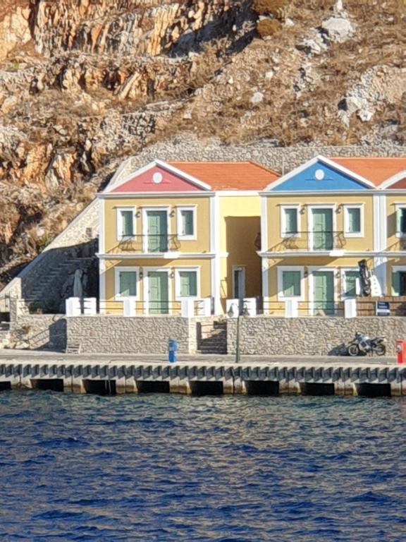 a row of houses on a dock in the water at Sea front Villas Danezis in Symi