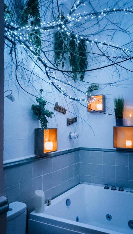 baño con bañera y luces en la pared en Suite con Burbuja, en Canyelles