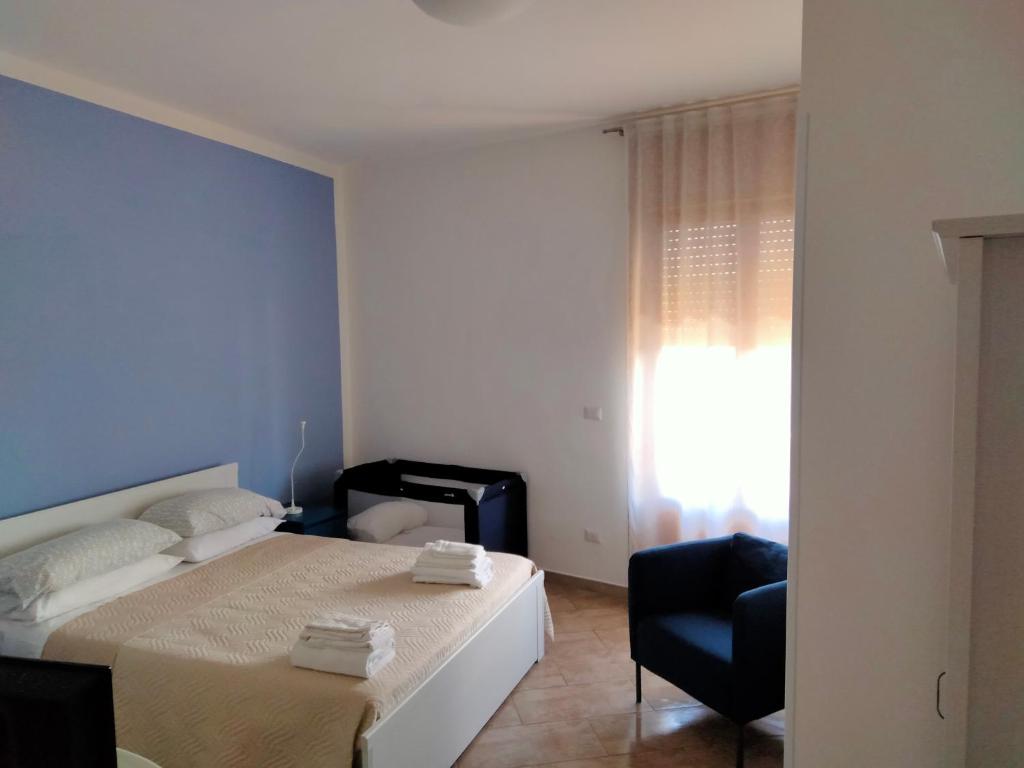 a bedroom with a bed and a chair and a window at Colori Del Salento in Cellino San Marco