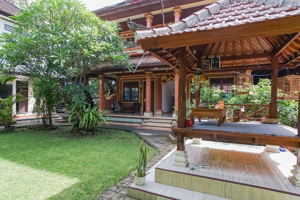 uma casa com um jardim em frente em Indopurejoy House - Komala Indah Cottages em Kuta