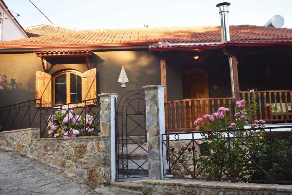 een huis met een poort en bloemen ervoor bij Capris Rustic Ηouse with Mountain View in Archaia Feneos