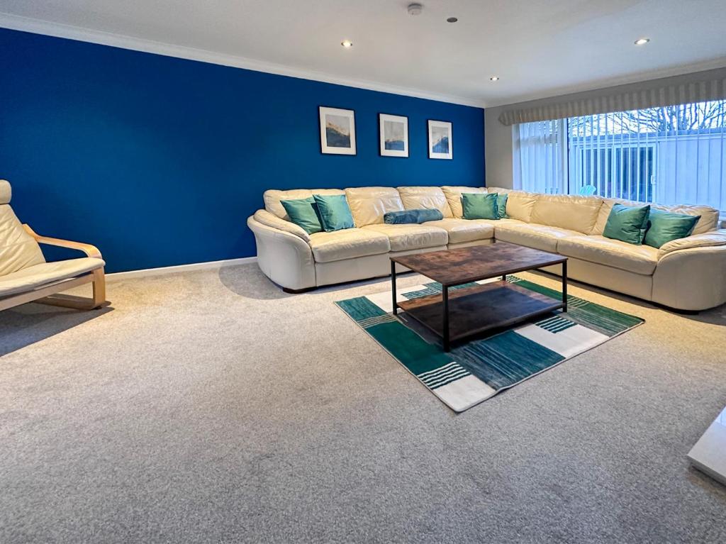 a living room with a couch and a table at BLUNSDON LODGE - Spacious Bungalow, High Speed Wi-Fi, Free Private Parking, Garden in Swindon