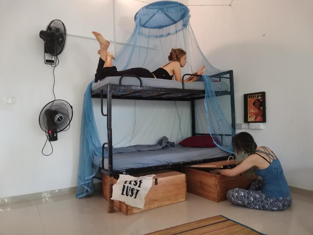 ウェリガマにあるWake Up Weligamaの二段ベッドの上に座る女性2名