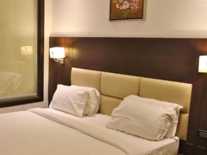 1 dormitorio con 1 cama con 2 almohadas blancas en Hotel namo, en Alwar