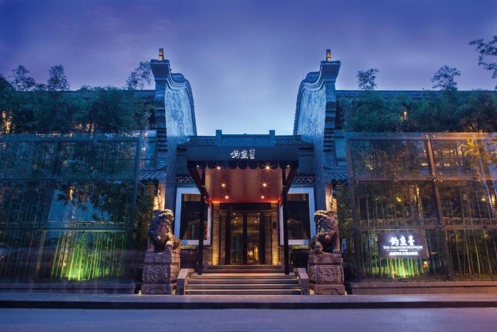 a building with two statues in front of it at Diaoyutai Boutique Hotel Chengdu in Chengdu