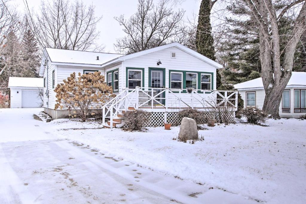une maison blanche avec de la neige au sol dans l'établissement Green Lake Vacation Home with Screened Porch!, à Green Lake