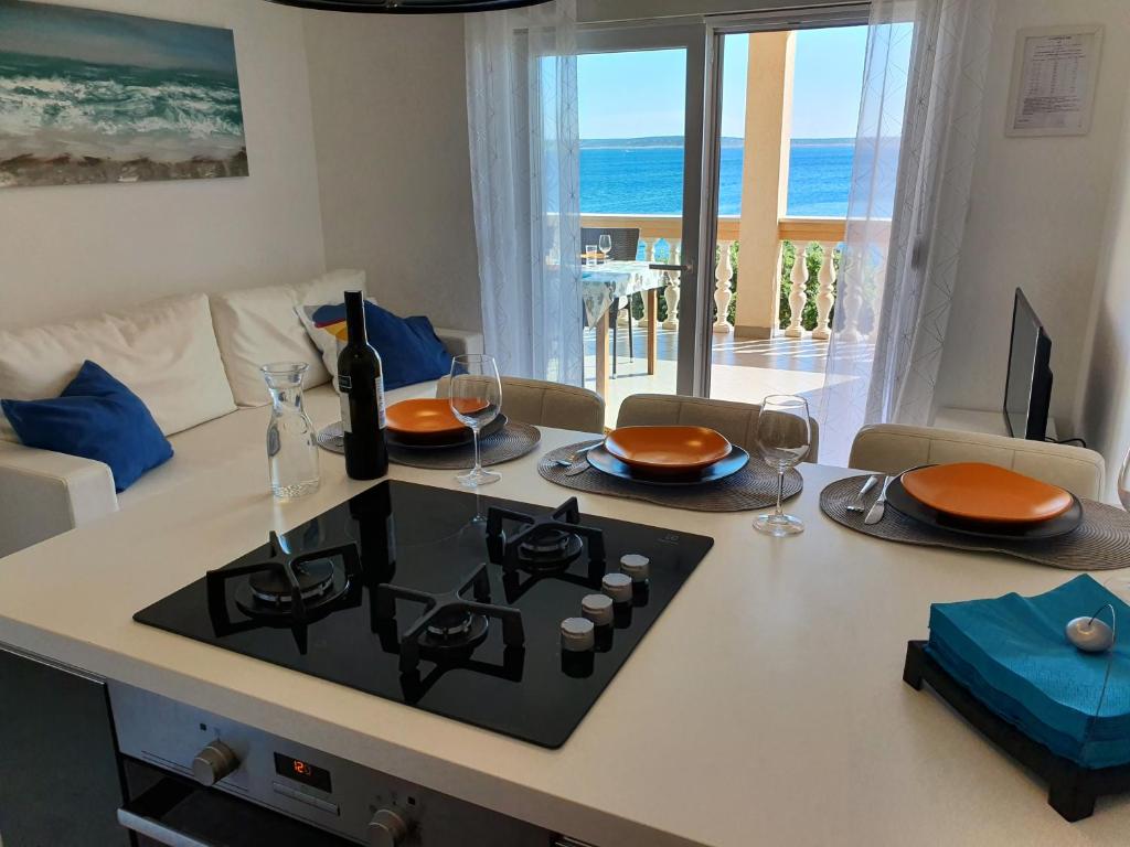 cocina con fogones y sala de estar con vistas al océano. en Comfortable family apt Iris 20m from beach in Mandre, en Mandre