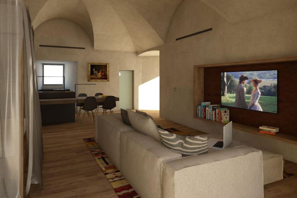 een woonkamer met een bank en een flatscreen-tv bij Le Coin du Château in Saint-Pierre