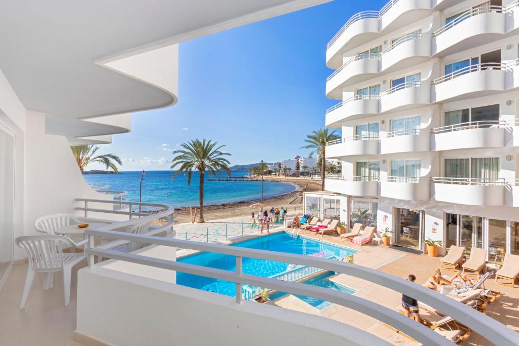 - une vue sur la piscine depuis le balcon de l'hôtel dans l'établissement Apartamentos Mar y Playa, à Ibiza