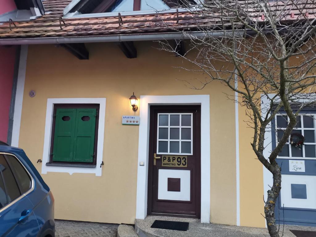 una casa con una porta verde e una macchina parcheggiata fuori di Appartement Terme Čatež P93 with Terme Tickets a Čatež ob Savi