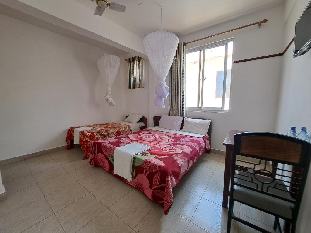 a bedroom with a red bed and a window at Kwale Golden Guest House in Kwale
