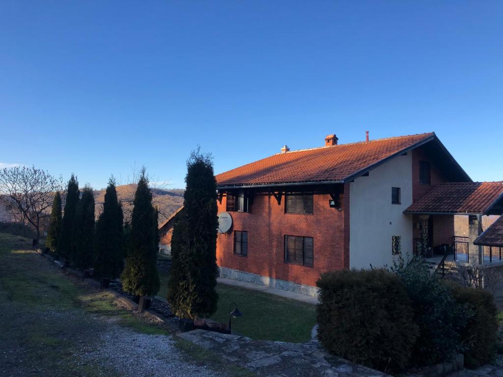 a brick house with trees in front of it at Vila Bojana in Gornji Milanovac