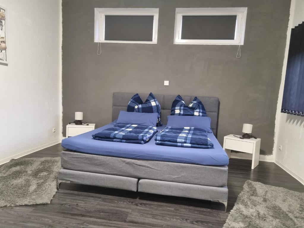 - une chambre avec un lit doté de draps et d'oreillers bleus dans l'établissement Appartment Barbier, à Großefehn 