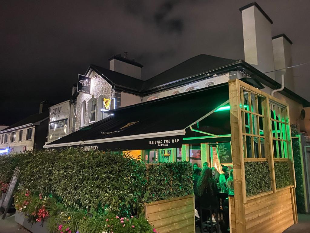 a restaurant with a green awning in front of a building at The Sliding Rock Inn in Galway