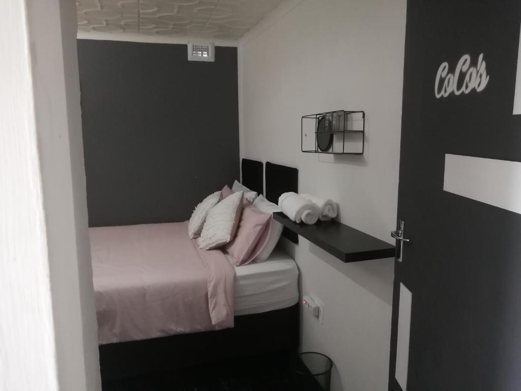 a small bedroom with a bed and a desk at Exquisite Minimalistic Room in Pietermaritzburg