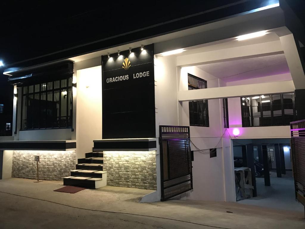 un edificio con un cartel en la parte delantera de la noche en Gracious Lodge, en Shillong