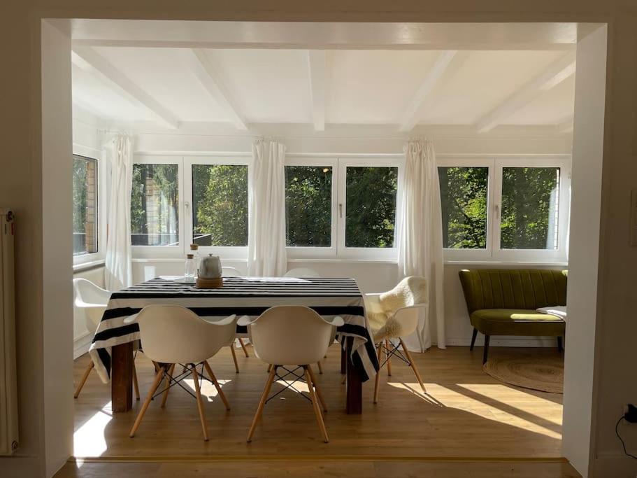 Langscheid的住宿－Sorpe Lodge - Entspannte Urlaubstage am See!，一间用餐室,配有黑白桌子和椅子