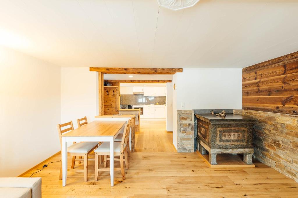 uma sala de jantar com uma mesa e um fogão em Casa Nacla Sedrun/Surrein em Sedrun