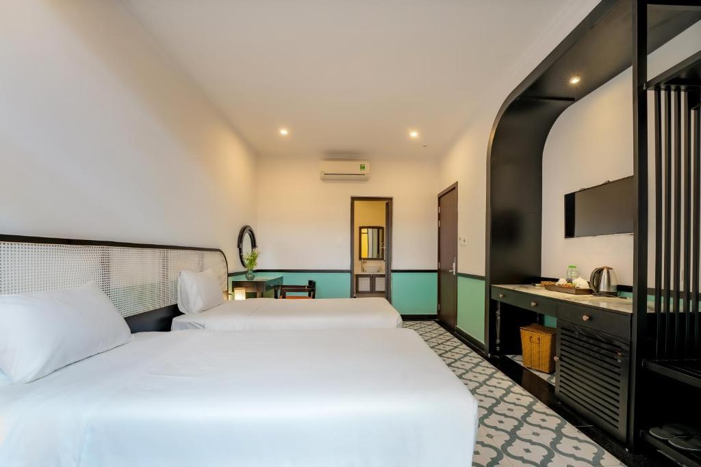 Postel nebo postele na pokoji v ubytování Hoi An Ivy Hotel