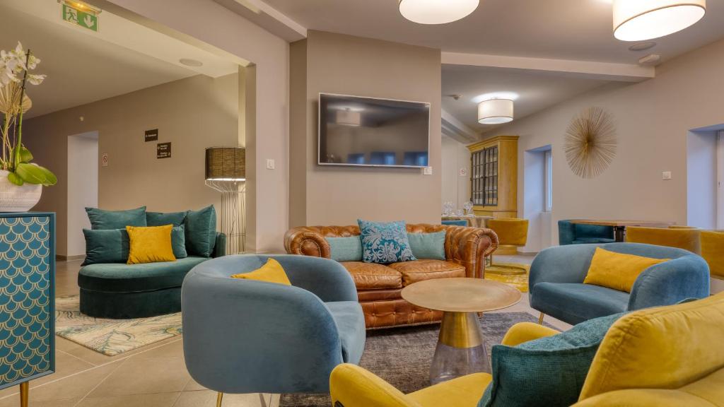 Televízia a/alebo spoločenská miestnosť v ubytovaní Hôtel L'Orée des plages