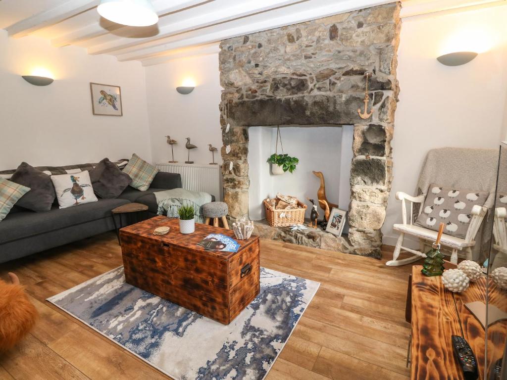 a living room with a large stone fireplace at Cudfan Fach in Pwllheli