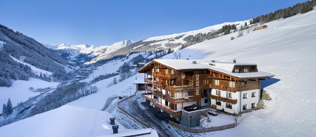a building on a snow covered mountain in the snow at Mei.Berg premium view Appartements in Saalbach-Hinterglemm