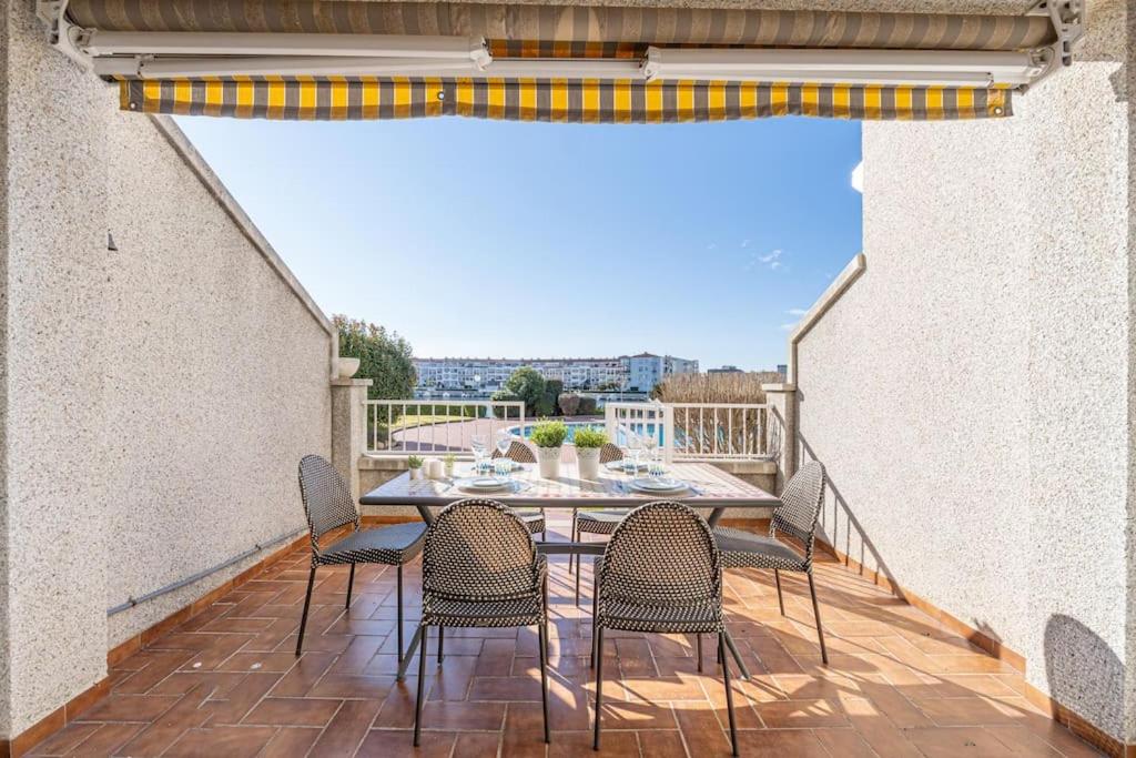 eine Terrasse mit einem Tisch und Stühlen auf dem Balkon in der Unterkunft 1014 Apartamento al lago San Maurici con 1 habitación y piscina in Empuriabrava