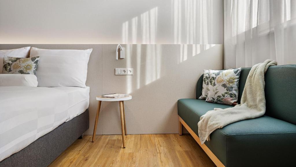 a bedroom with a bed and a chair at Styles Hotel Karlsruhe Messe in Karlsruhe