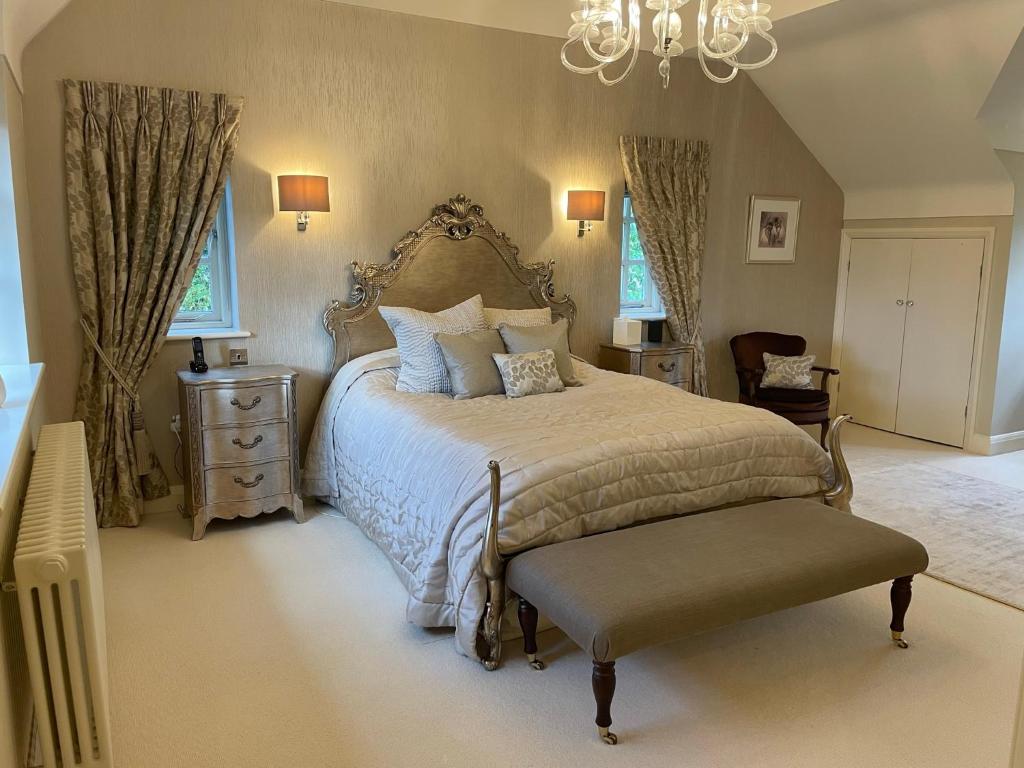 a bedroom with a large bed and a chandelier at Appletree Cottage in Heswall