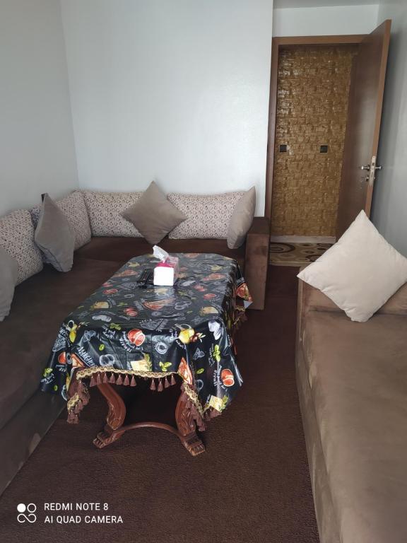 sala de estar con mesa y sofá en طريق أشقار العرفان 3 en Tánger