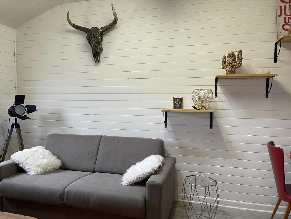 ein Wohnzimmer mit einer Couch und einem Stierkopf an der Wand in der Unterkunft Appartement au centre de Dinard in Dinard