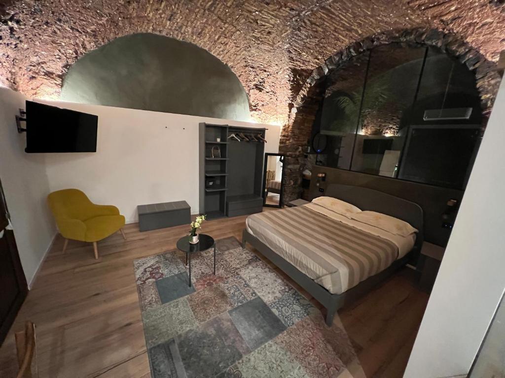 una camera con un letto in un muro di mattoni di Suite Gallo a Catania
