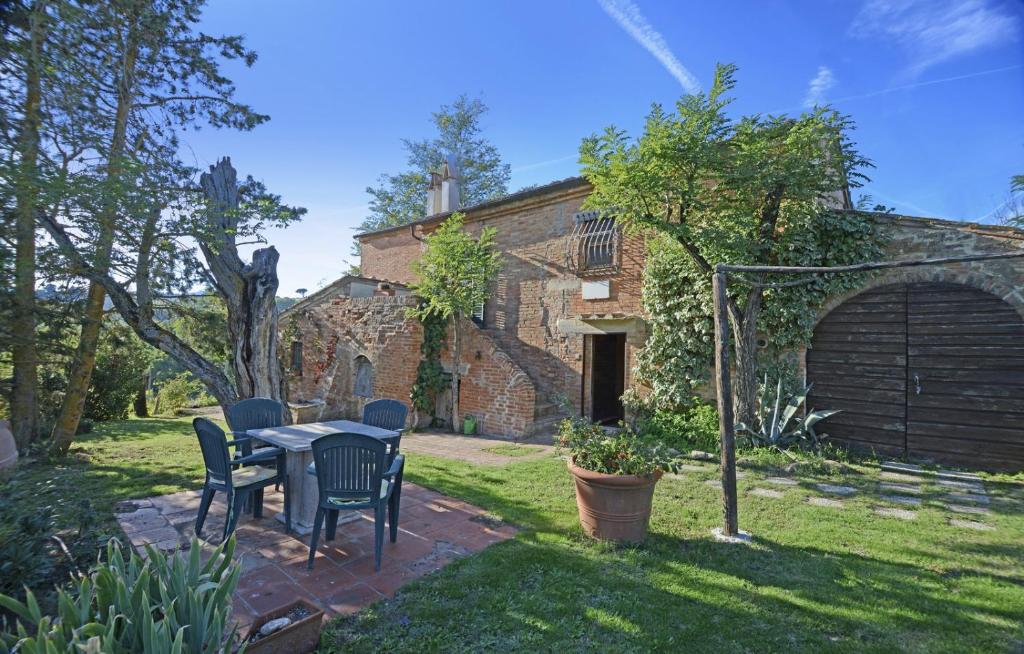 a patio with a table and chairs in a yard at Podere Le Crete in Montepulciano