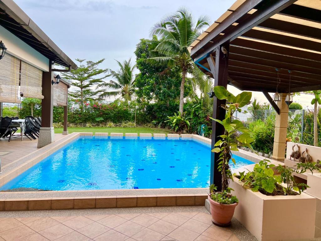 a swimming pool in a yard with a house at Melaka Beachfront Villa with Pool in Melaka
