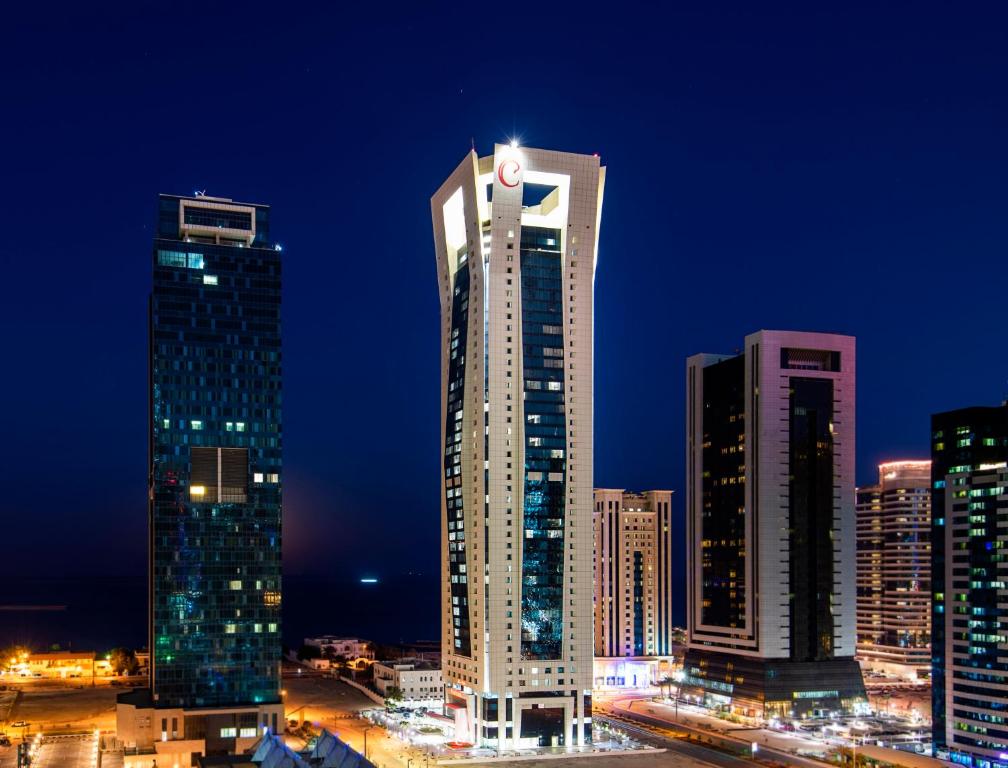 杜哈的住宿－Centara West Bay Hotel & Residences Doha，城市天际线,晚上有高楼