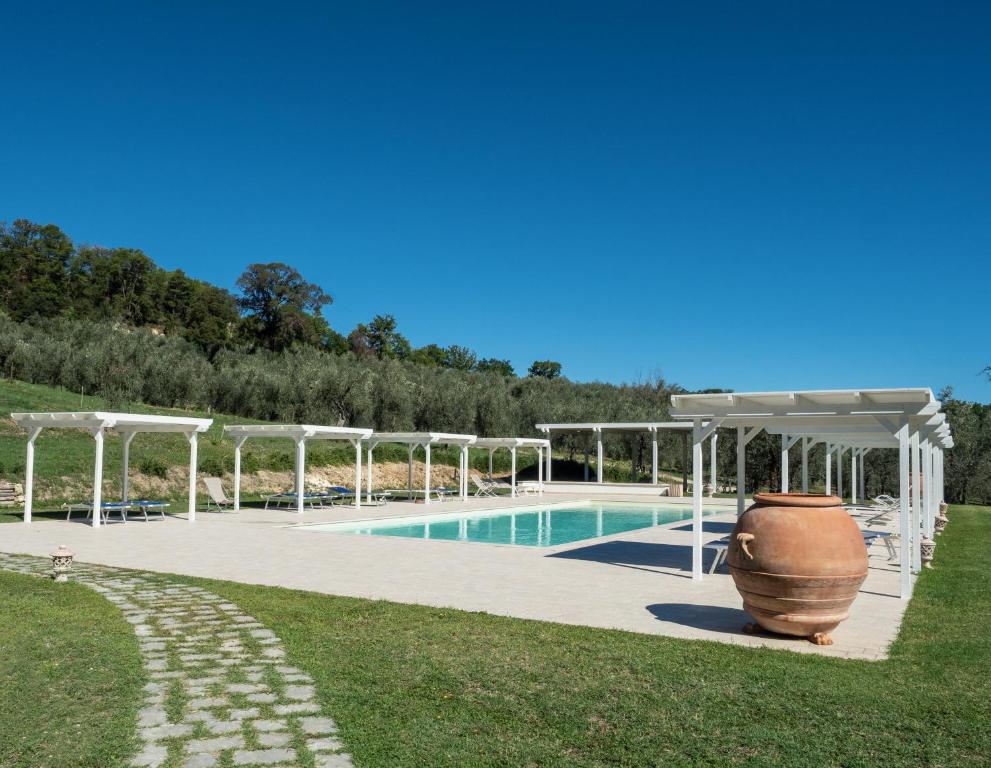 uma piscina com uma pérgola e um vaso grande num quintal em Il Borgo Di San Michele em Papigno