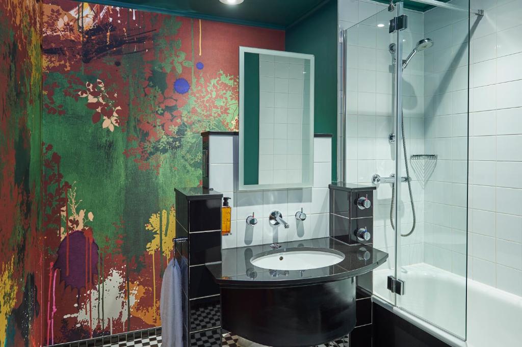 a bathroom with a sink and a painting on the wall at Malmaison Manchester in Manchester