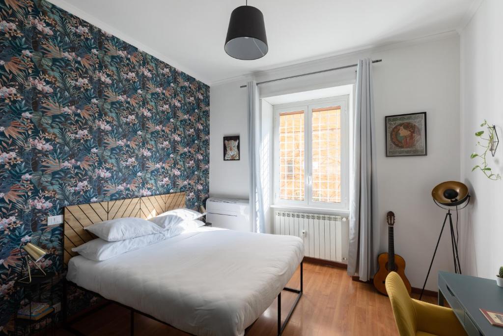 a bedroom with a bed with a floral wallpaper at Domus Vaticana in Rome