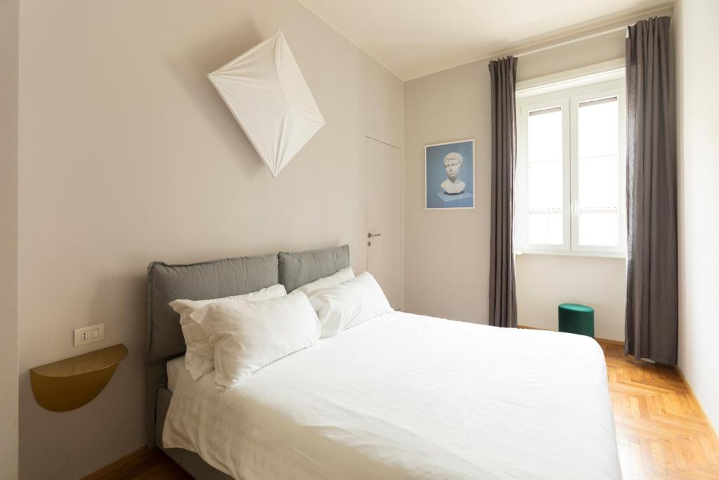ein Schlafzimmer mit einem weißen Bett und einem Fenster in der Unterkunft Duomo big apartment in Mailand