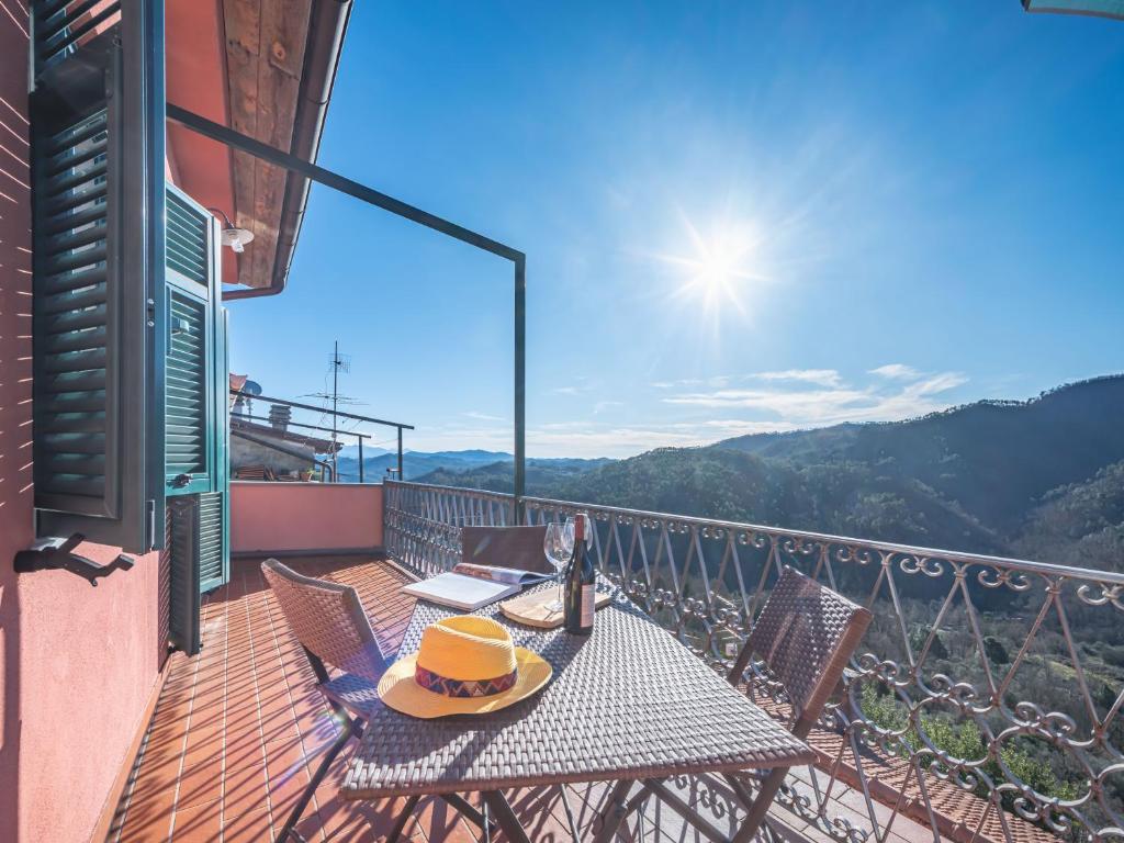 una mesa y sillas en un balcón con vistas en Alpi Apuane Panoramic Apartment, en Carrodano Inferiore