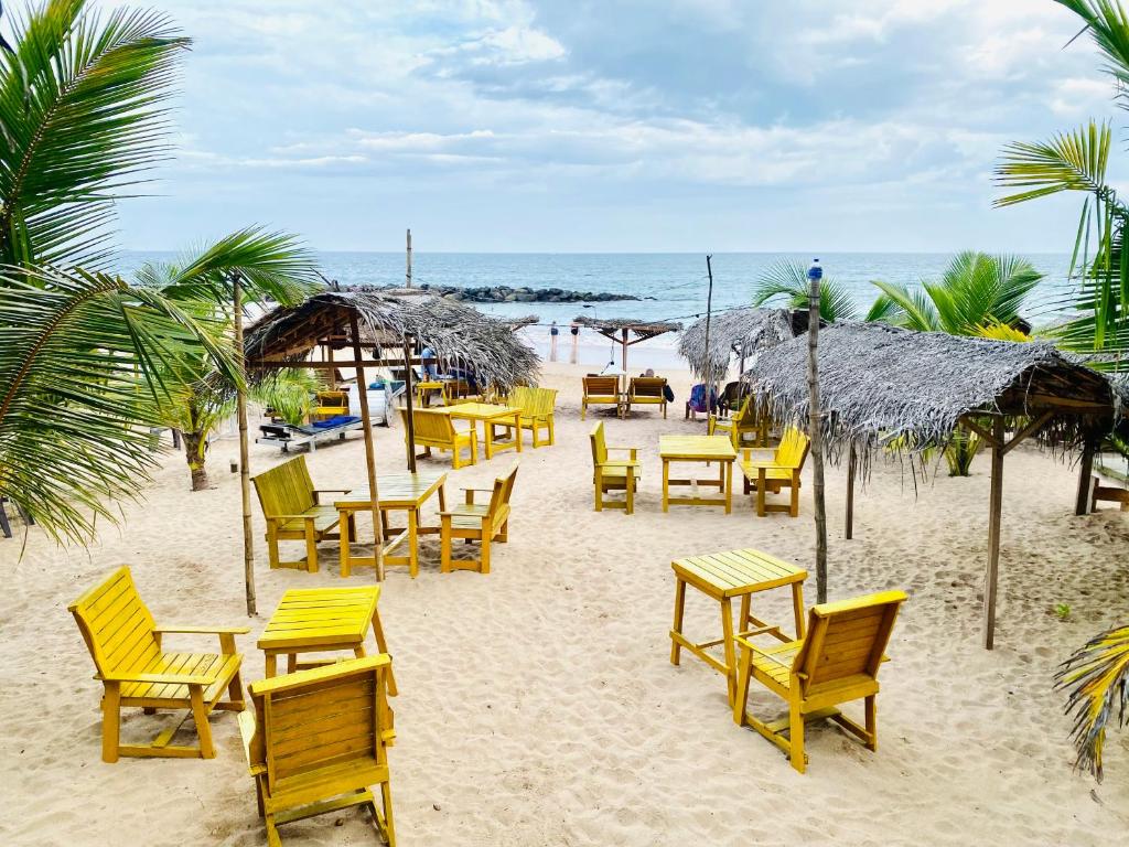 un gruppo di sedie e tavoli sulla spiaggia di Inu Vicky Beach Hotel a Tangalle