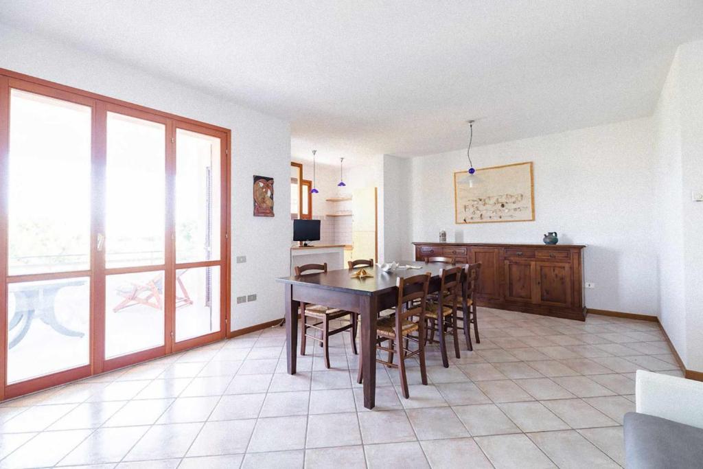 cocina y comedor con mesa y sillas en R08 Ampio trilocale con terrazzo panoramico, en Marcelli