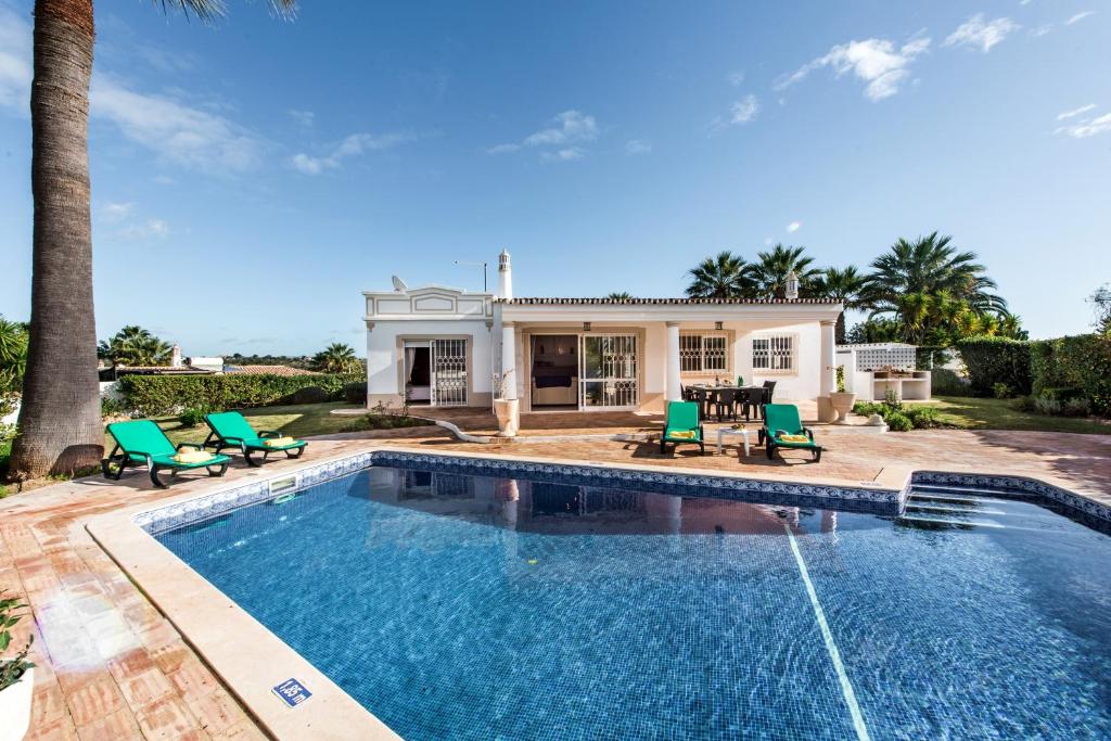 a swimming pool in front of a house at Celina by Algarve Villa Holidays in Guia