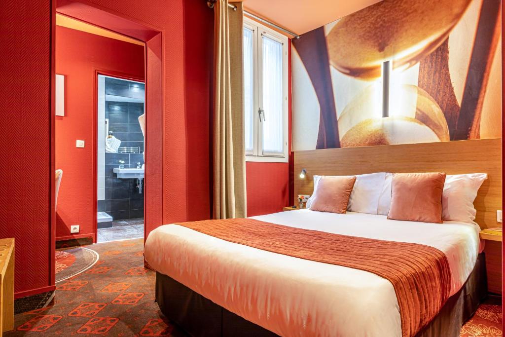 a hotel room with a bed with red walls at Hotel Ariane Montparnasse by Patrick Hayat in Paris