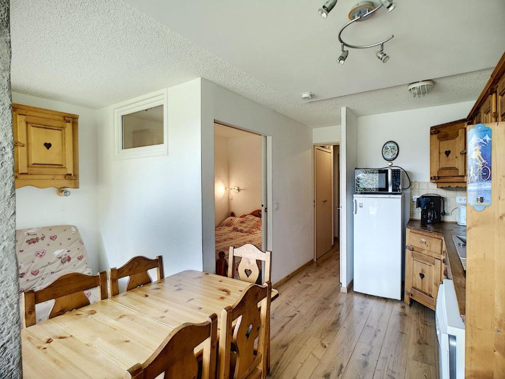 een keuken en eetkamer met een tafel en een koelkast bij Appartement Les Menuires, 2 pièces, 6 personnes - FR-1-178-325 in Les Menuires