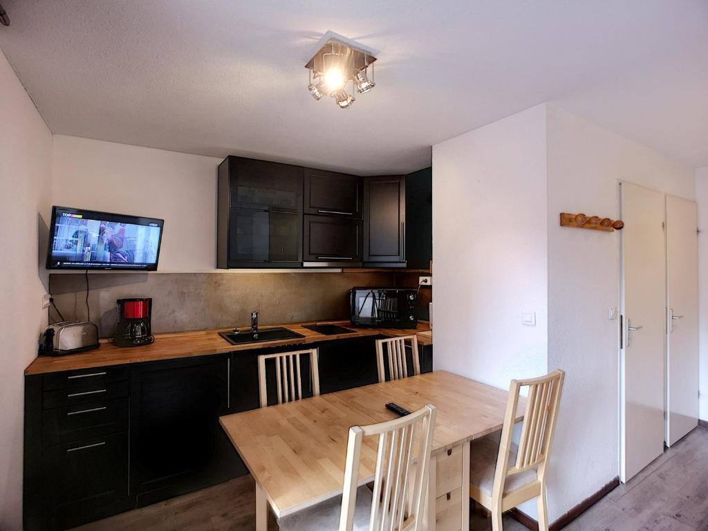 Il comprend une cuisine avec une table et des chaises en bois. dans l'établissement Joli 2P pour 4, au pied des pistes, quartier Bruyères, Les Menuires - FR-1-178-332, aux Menuires