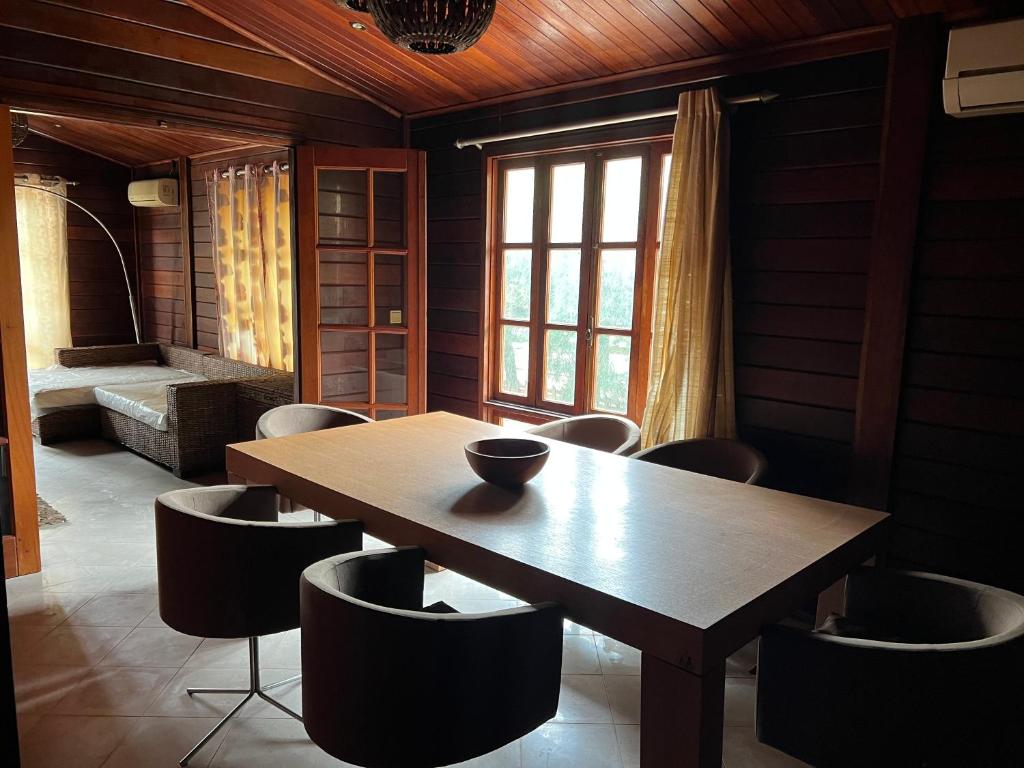 uma sala de jantar com uma mesa de madeira e cadeiras em A 1 minuto do Mar! Casa Mármore V4 em Zona Sossegada na Ilha do Mussulo em Belas
